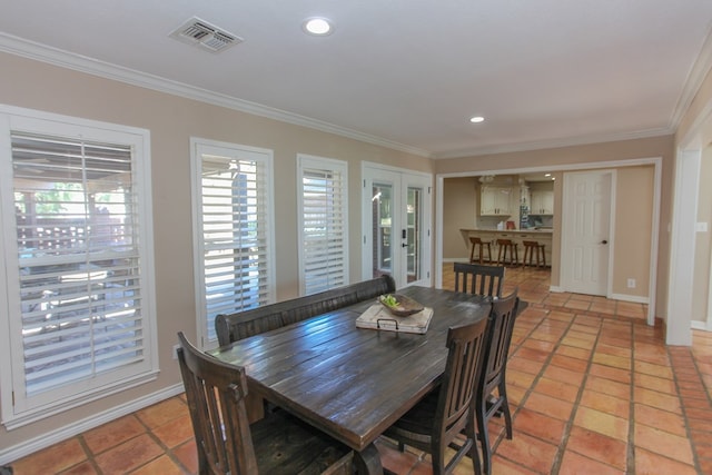 dining space featuring french doors, ornamental molding, and light tile patterned flooring