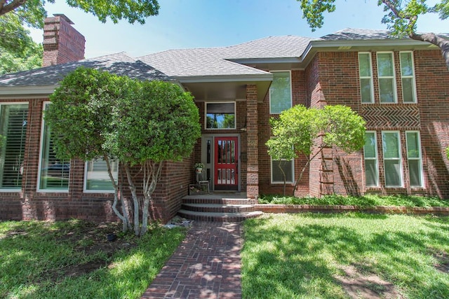 entrance to property featuring a yard