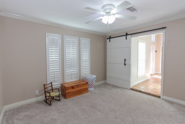 interior space with light carpet, ornamental molding, a barn door, and ceiling fan