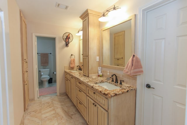 bathroom with vanity, decorative backsplash, and toilet