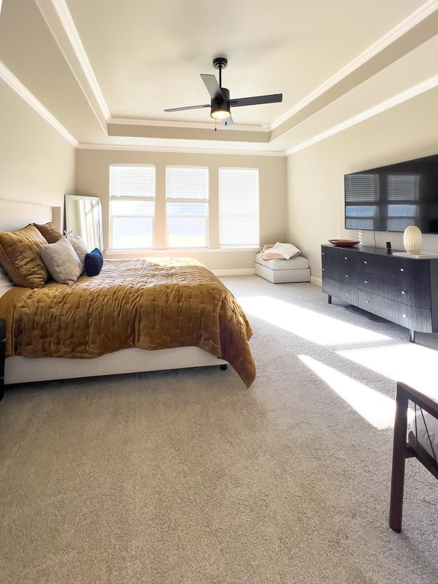 carpeted bedroom featuring a ceiling fan, a raised ceiling, and crown molding