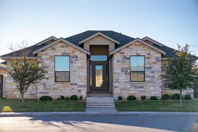 view of front of home with a shingled roof and a front yard