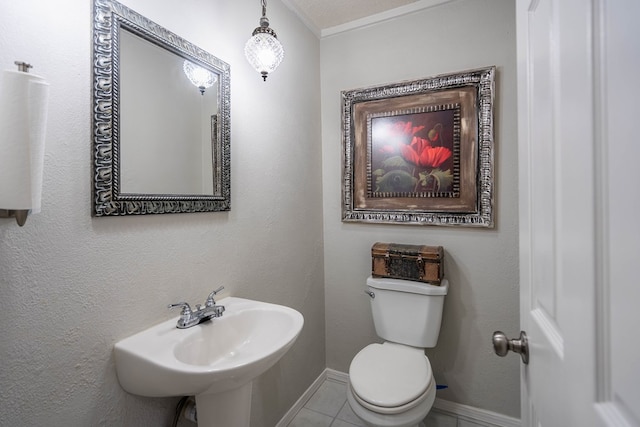 bathroom featuring a sink, baseboards, toilet, and tile patterned flooring