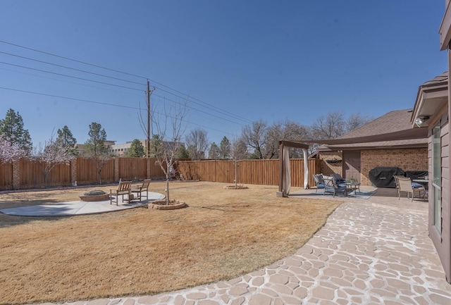 view of yard featuring a fenced backyard, a fire pit, and a patio