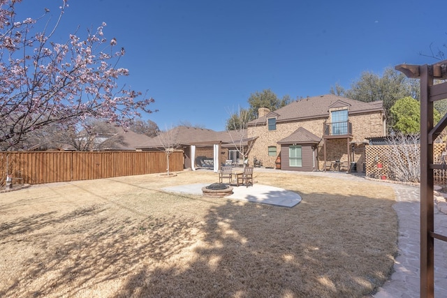 back of property featuring a patio, a fire pit, and fence