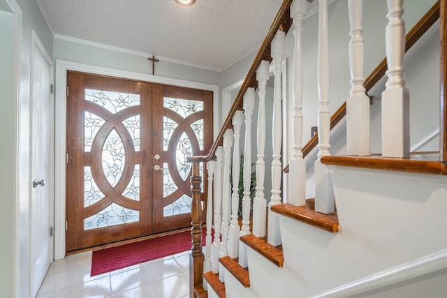 entrance foyer with light tile patterned floors, a healthy amount of sunlight, and a textured ceiling