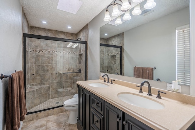 bathroom featuring a textured ceiling, a shower stall, toilet, and a sink