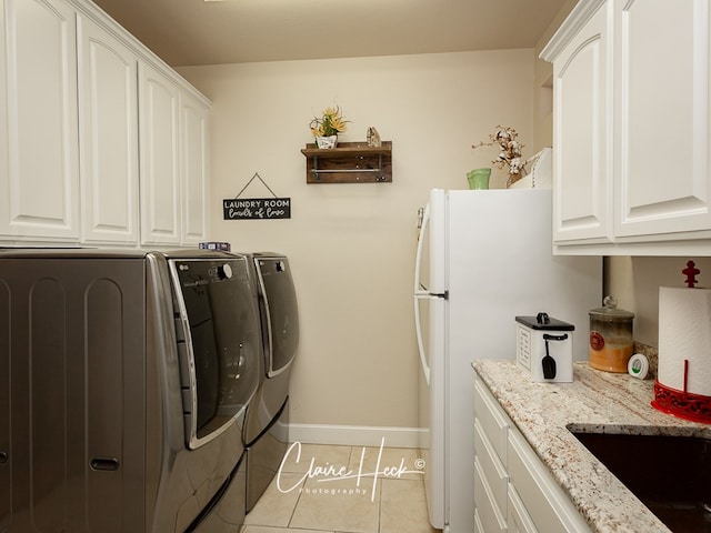 laundry area featuring light tile patterned flooring and washer and clothes dryer