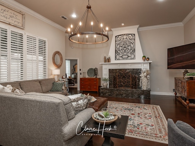 living room featuring an inviting chandelier, crown molding, a high end fireplace, and dark hardwood / wood-style floors