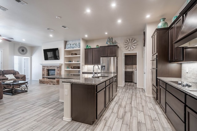 807 Bronco Ct, Midland, TX 79705 - kitchen with stainless steel appliances, premium range hood, open floor plan, a ceiling fan, and light wood finished floors