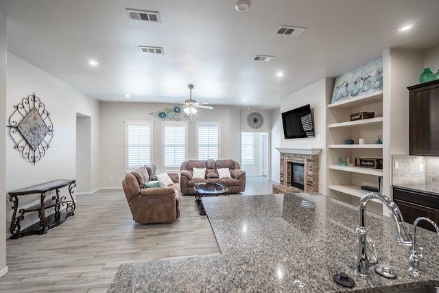 807 Bronco Ct, Midland, TX 79705 - living room featuring a brick fireplace, light wood-style floors, a ceiling fan, and recessed lighting