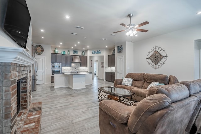 807 Bronco Ct, Midland, TX 79705 - living area featuring light wood-type flooring, ceiling fan, a fireplace, and recessed lighting