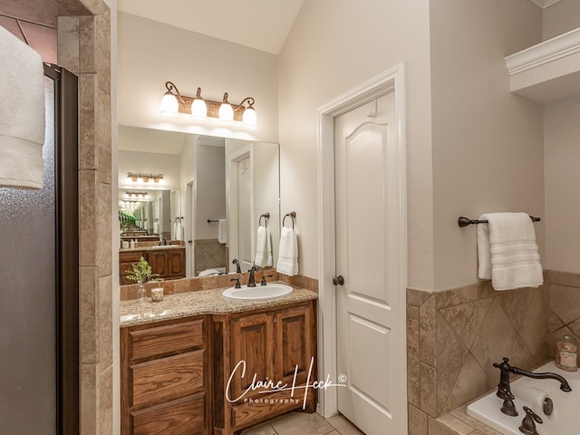 full bath with a garden tub, tile patterned flooring, and vanity