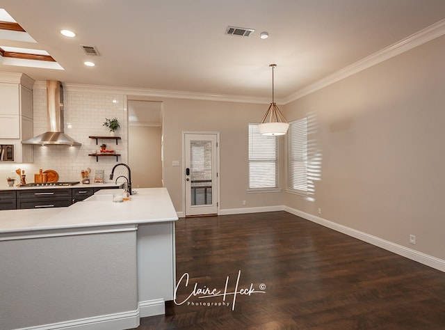 5305 Wimberley Spring Ct, Midland, TX 79707 - kitchen featuring wall chimney range hood, light countertops, ornamental molding, decorative backsplash, and a sink
