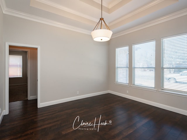 unfurnished room featuring crown molding, a tray ceiling, dark wood finished floors, and baseboards