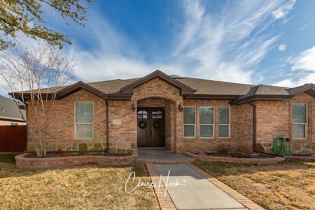 ranch-style house with brick siding, a shingled roof, and fence