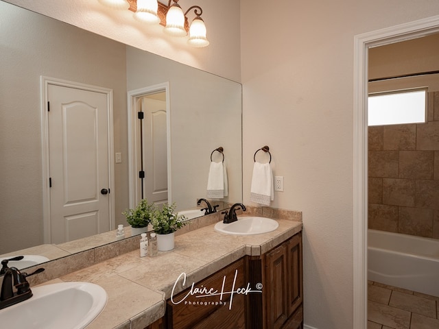 full bathroom featuring a notable chandelier, a sink, and double vanity