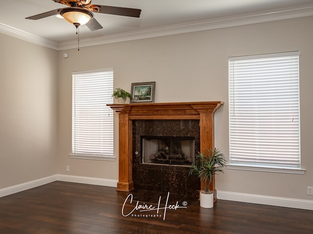 living room featuring baseboards, a ceiling fan, a premium fireplace, wood finished floors, and crown molding