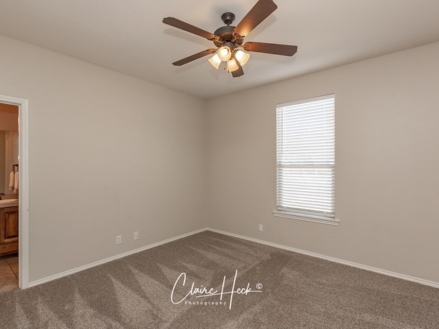 empty room with carpet, baseboards, and a ceiling fan