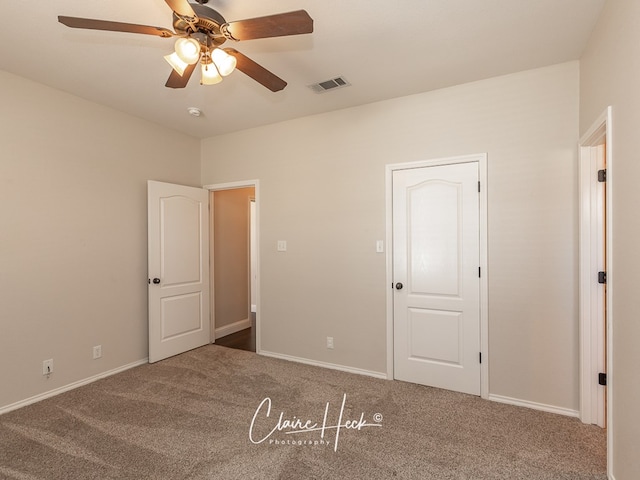 unfurnished bedroom featuring carpet floors, baseboards, visible vents, and ceiling fan