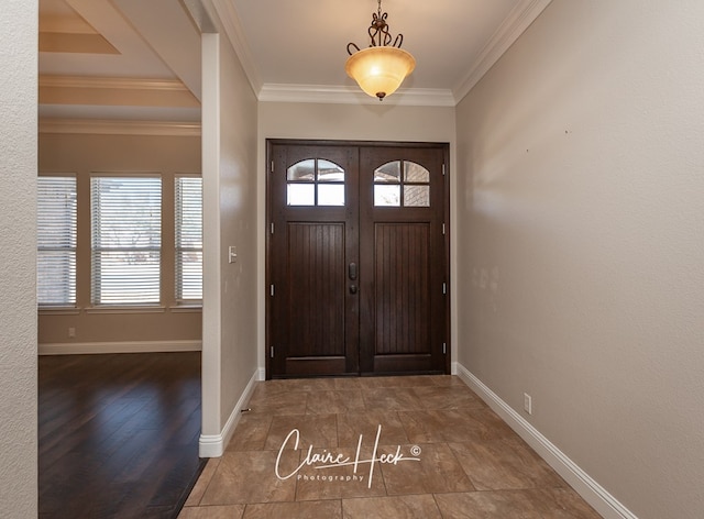 entryway featuring a wealth of natural light, crown molding, and baseboards