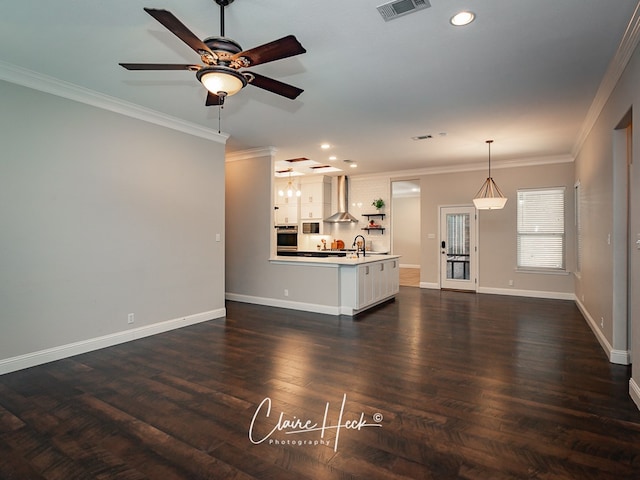 unfurnished living room featuring recessed lighting, dark wood-style flooring, a sink, baseboards, and ornamental molding