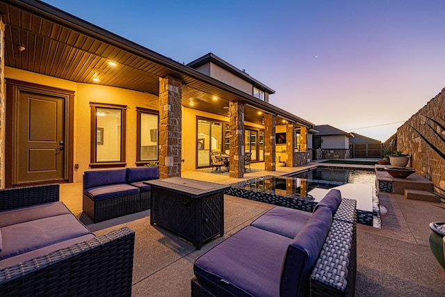 patio terrace at dusk with an outdoor living space with a fire pit