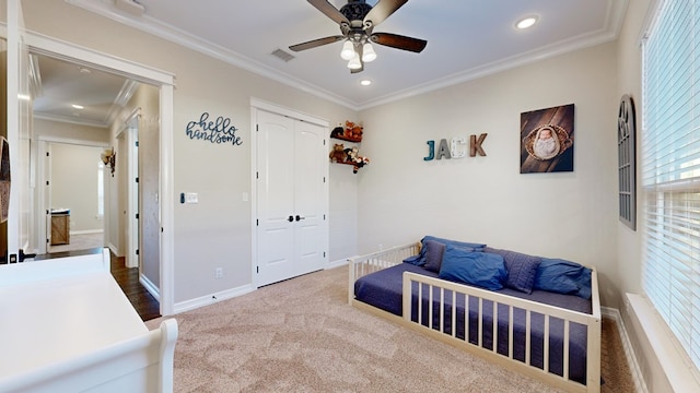 carpeted bedroom featuring crown molding, ceiling fan, and a closet