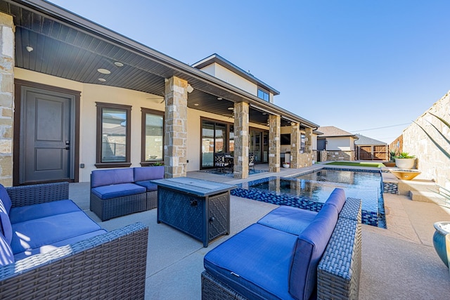 view of pool with an outdoor living space with a fireplace and a patio area