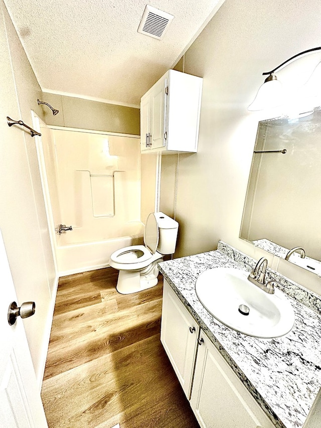 1401 Brand Ln, Midland, TX 79705 - bathroom featuring wood finished floors, a textured ceiling, vanity, toilet, and visible vents