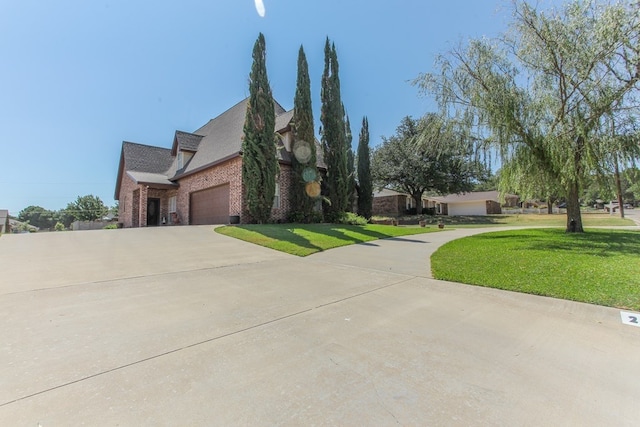 2901 Stonehaven Dr, Big Spring, TX 79720 - view of property exterior featuring brick siding, driveway, a garage, and a lawn