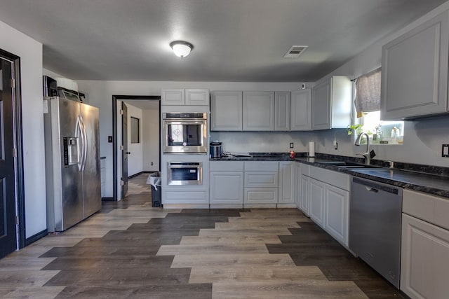 600 NW 8th St, Big Spring, TX 79720 - kitchen with stainless steel appliances, dark countertops, and wood finished floors