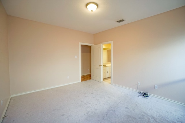 spare room with light carpet, baseboards, and visible vents