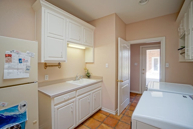 kitchen with light countertops, freestanding refrigerator, and white cabinetry