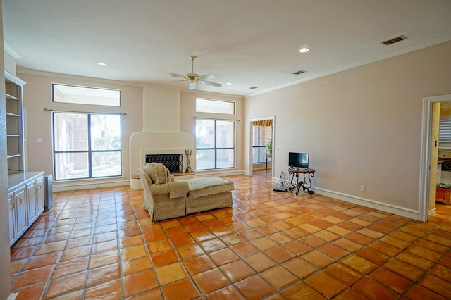 living area with ornamental molding, a fireplace with raised hearth, baseboards, and light tile patterned flooring