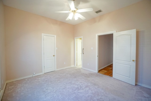 unfurnished bedroom with light colored carpet, visible vents, ceiling fan, and baseboards