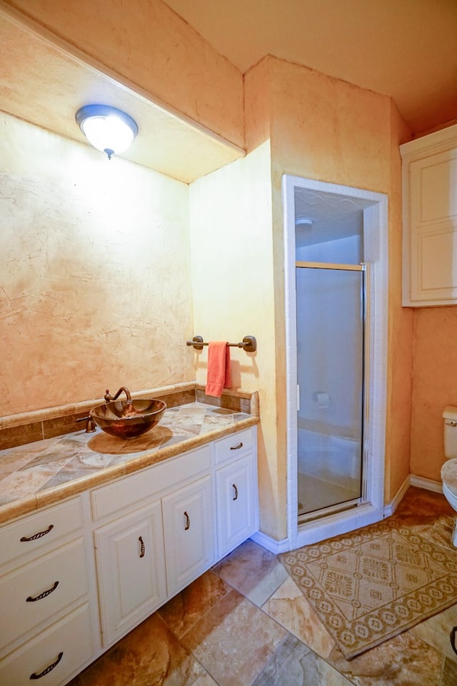 bathroom with a stall shower, vanity, and toilet