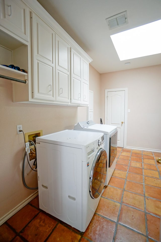 laundry area featuring a skylight, washer and clothes dryer, light tile patterned floors, visible vents, and cabinet space