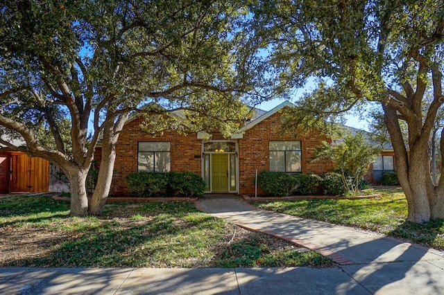 single story home with fence, a front lawn, and brick siding