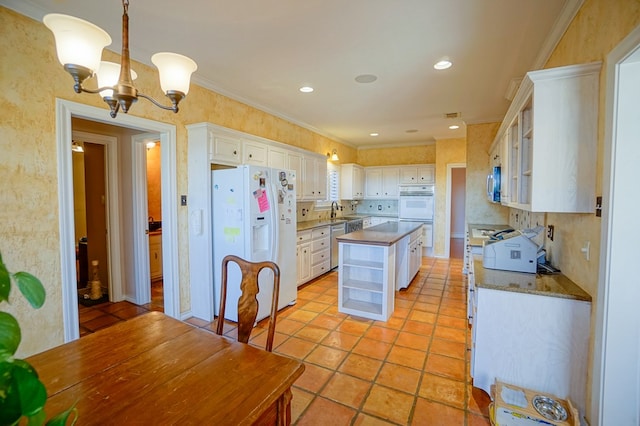 kitchen featuring white appliances, white cabinetry, hanging light fixtures, open shelves, and glass insert cabinets