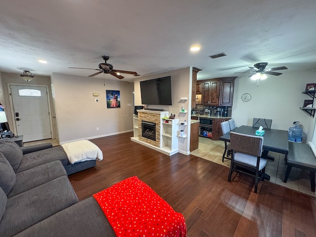 living area featuring visible vents, ceiling fan, and wood finished floors