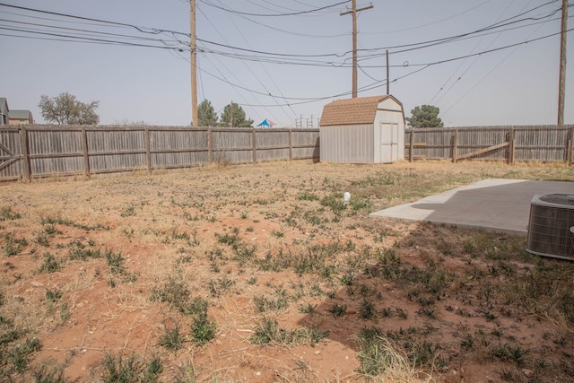 view of yard featuring a storage shed, a fenced backyard, an outdoor structure, and a patio