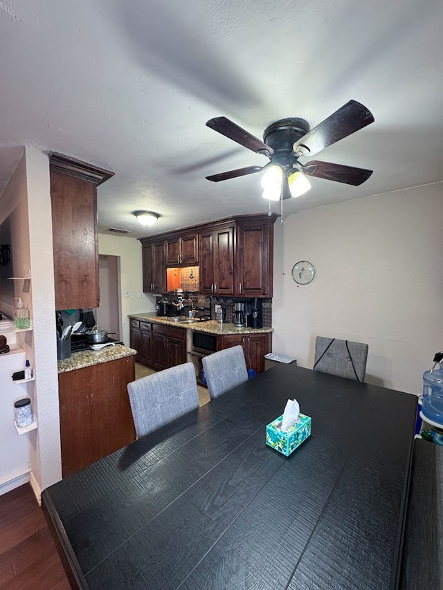 dining area featuring ceiling fan and dark wood-style flooring