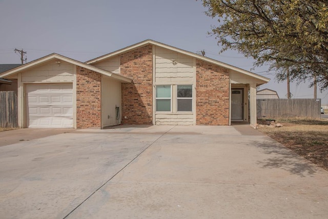 mid-century inspired home featuring brick siding, driveway, a garage, and fence