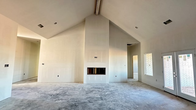 unfurnished living room featuring beam ceiling and high vaulted ceiling