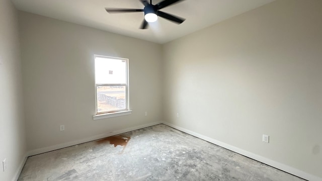 empty room with a ceiling fan and baseboards