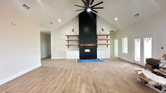 unfurnished living room featuring light wood-type flooring, visible vents, high vaulted ceiling, a ceiling fan, and baseboards