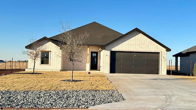 view of front of property with brick siding, concrete driveway, and an attached garage