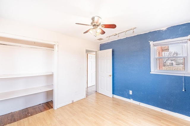 1204 Tinker St, Seagraves, TX 79359 - unfurnished bedroom with ceiling fan, light wood finished floors, rail lighting, and baseboards
