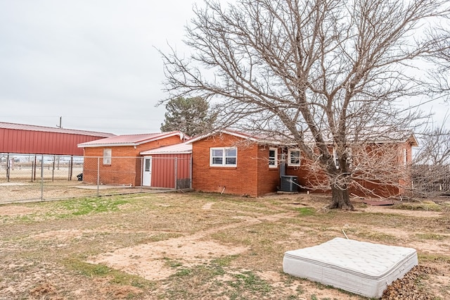 1204 Tinker St, Seagraves, TX 79359 - back of house featuring fence, cooling unit, and brick siding